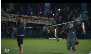 广西有县超足球比赛休息中，一大群的爷爷、奶奶们扛着农具走到绿茵场上表演了。
第一