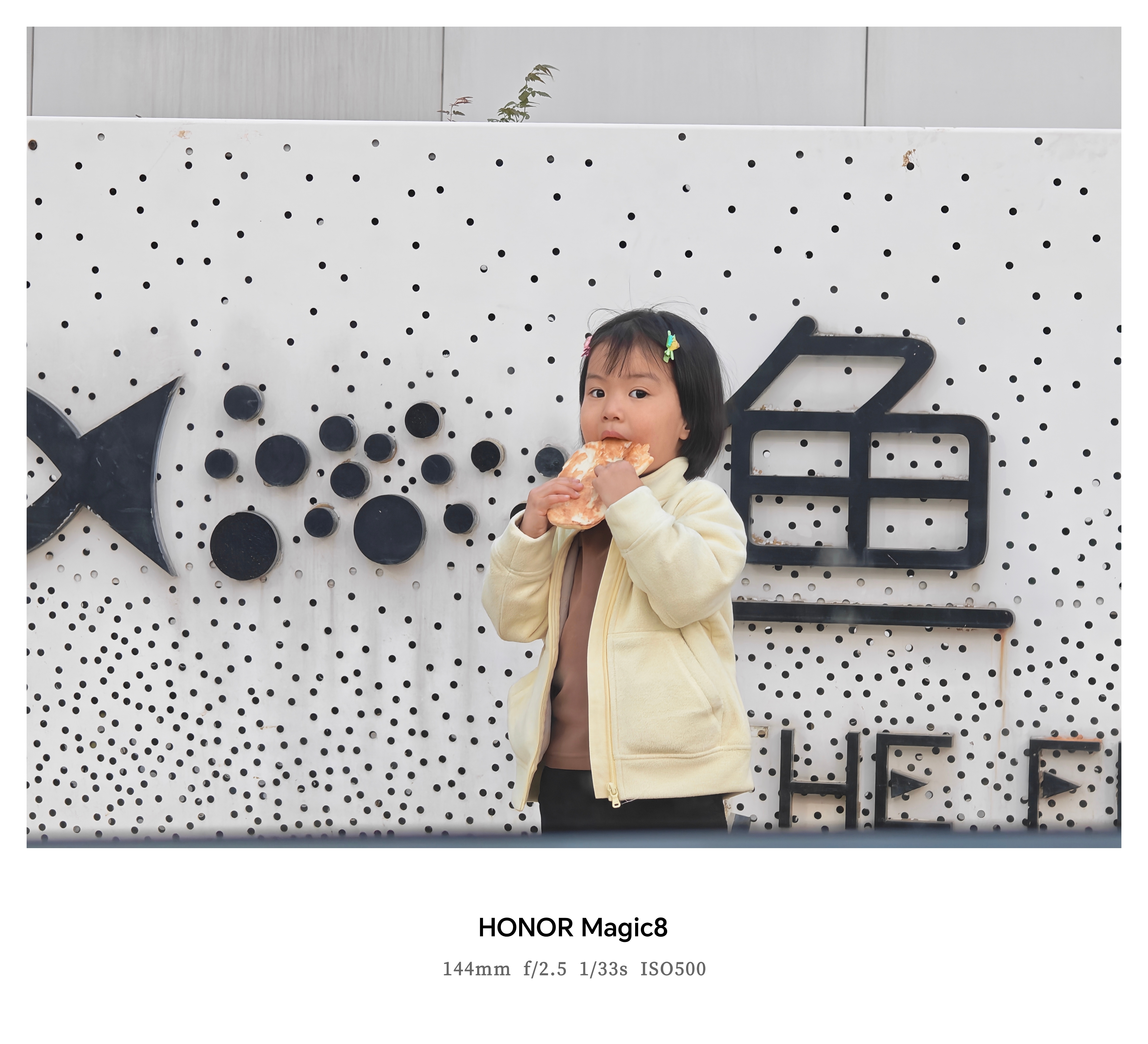 在车内透过车窗抓拍的一个在路边吃饼的小女孩，小小的身子却吃着大大的饼，真的好可爱