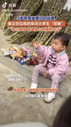 “暖心！”陕西汉中，一3岁女孩坐在家附近等奶奶时，被路过军训的大学生注意到，每个
