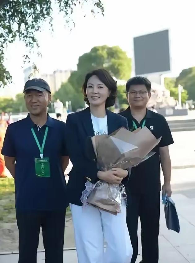 离开央视后的短发女主持状态惊艳！活动现场手捧鲜花，笑容温柔松弛。
身旁两名工作人