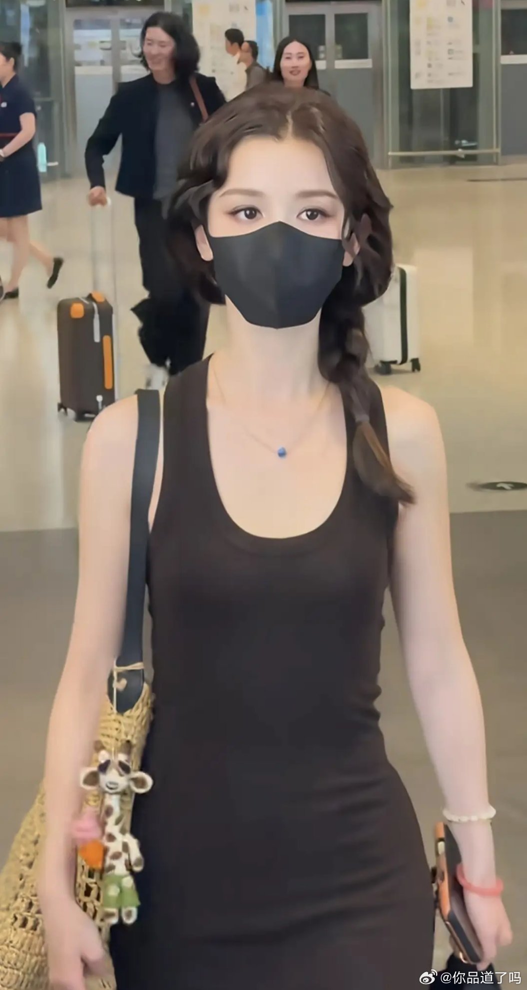 哈妮机场出行路透曝光，肤白身形纤瘦，一袭黑色紧身长裙勾勒曼妙曲线，体态轻盈亮眼。