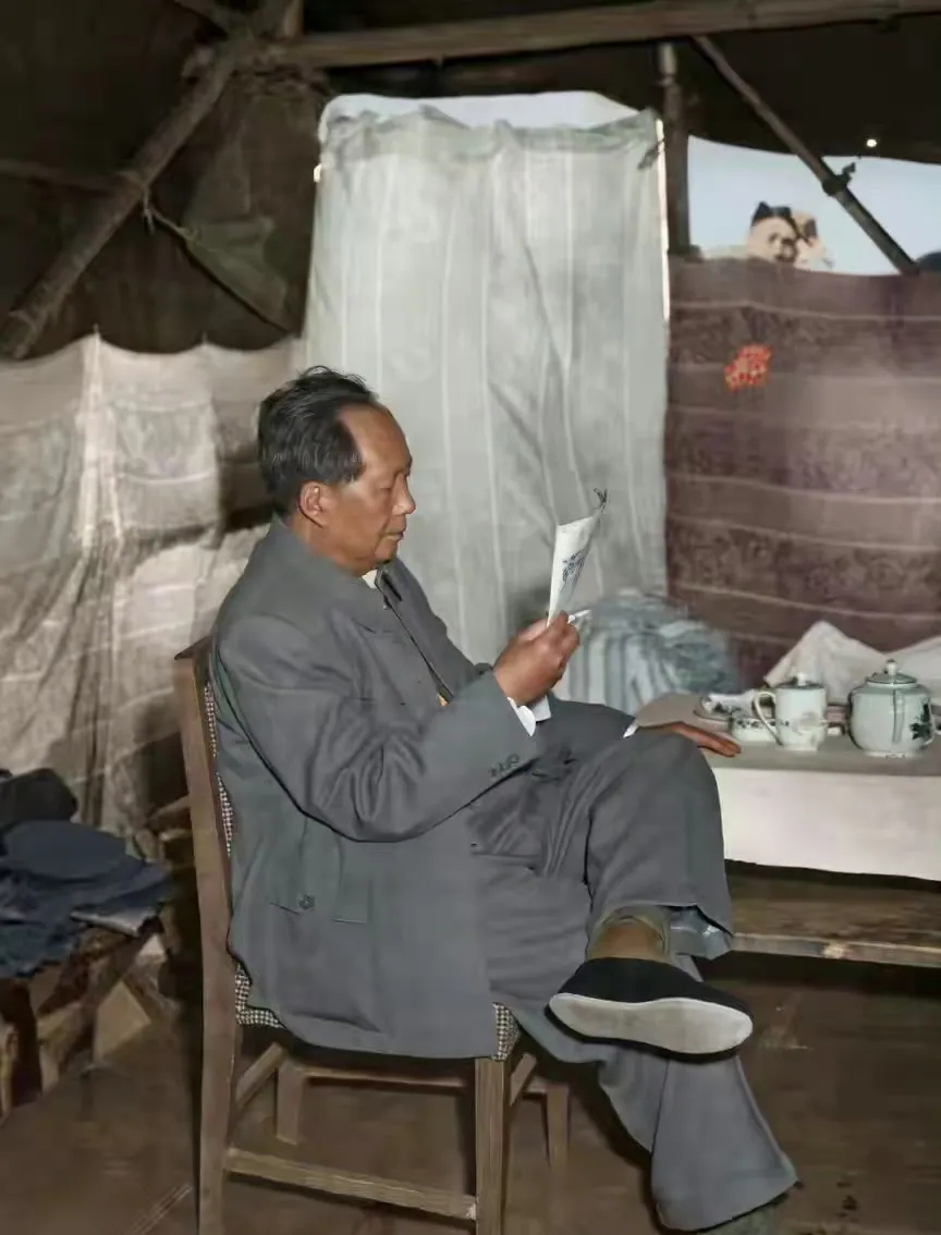 有人偷看毛主席工作。毛主席外出时，坐在临时搭建的简陋的休息间，专注地看文件。一男