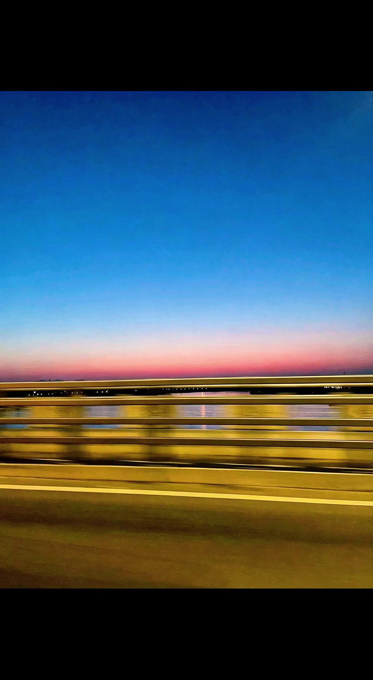 🌆车窗框住流动的橘海，栏杆是时光的琴键🎹。奔赴下一场日落，还是追赶未完成的梦