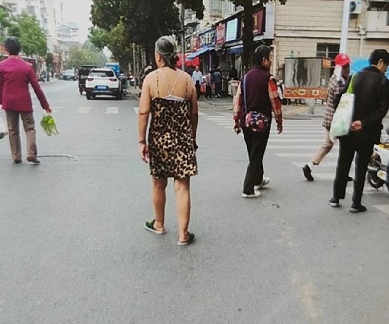 这么冷的天气，老太太居然这样的穿着，让我心里很不是滋味，觉得这是一位精神病人！真