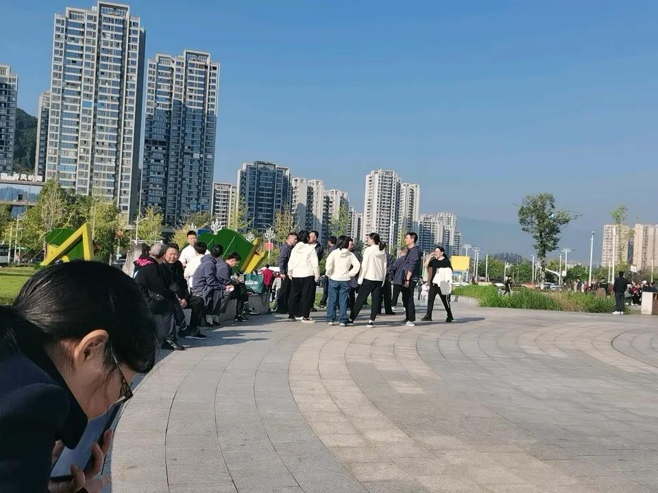 秋日生活打卡季广场上到处是晒太阳，参加秋日活动的人们。