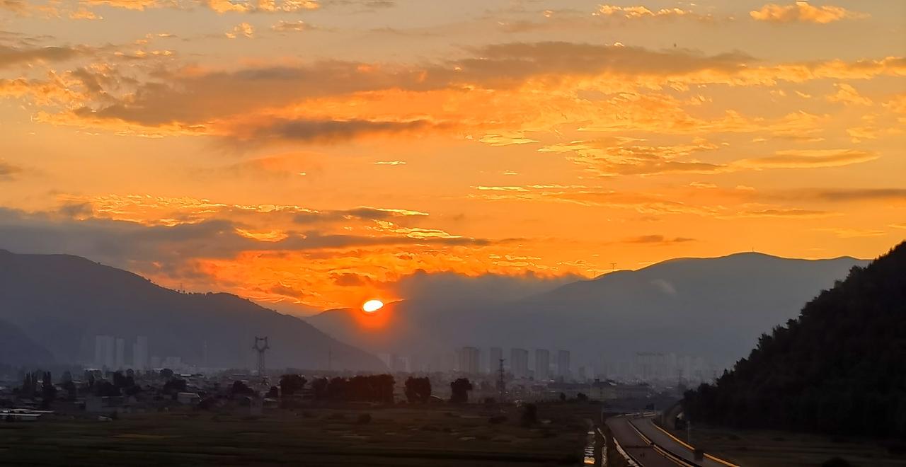 夕阳西下，余晖洒满大地，城市与自然和谐共存。