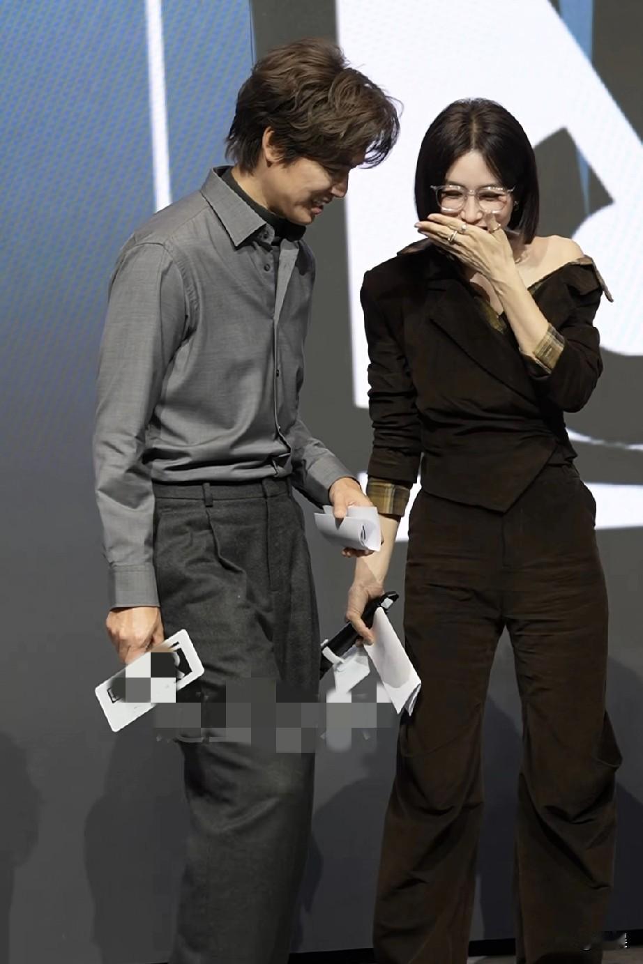 钟汉良与秦岚同框，钟汉良身着简约干练的灰色衬衫搭配深色西裤，尽显成熟儒雅气质。秦