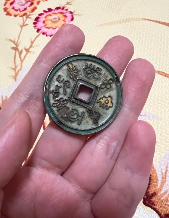爷爷留下一枚花钱，正面刻着十二生肖和八卦符号，填了彩色的珐琅，背面刻着龙纹，也有