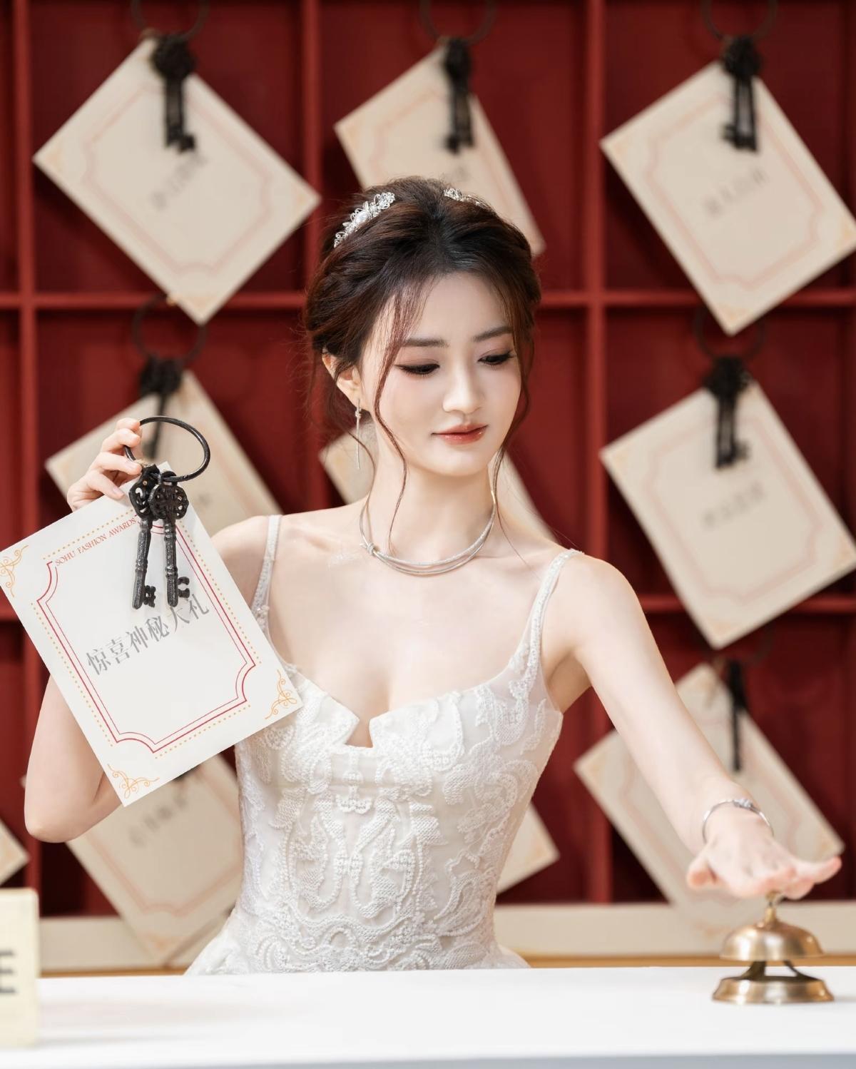  轻纱质感的白色抹胸裙，层叠裙摆漾着灵动气息，徐璐举手投足间既有少女的清甜，又有