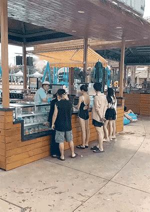 一个早上，有一个穿着清凉、看起来心情美美哒的女人，刚从热气腾腾的早餐摊前接过她的