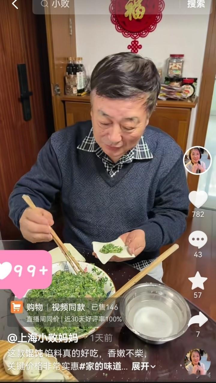 上海小败爸爸又在厨房忙活了。他身穿一件深蓝色 V领针织衫，内搭一件经典的黑白格纹