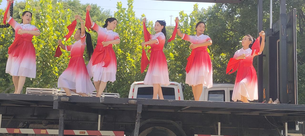秋日生活打卡季 这位女士站在花丛中，背景很美。