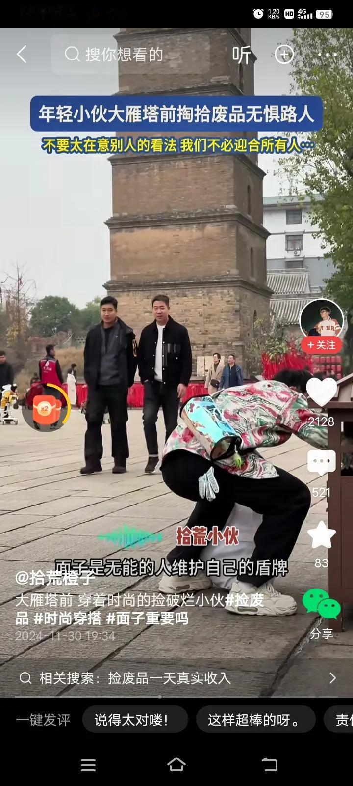 一位穿着很时尚的年轻的小伙子，在大雁塔前捡废品，马路上人来人往，但小伙子依然无所