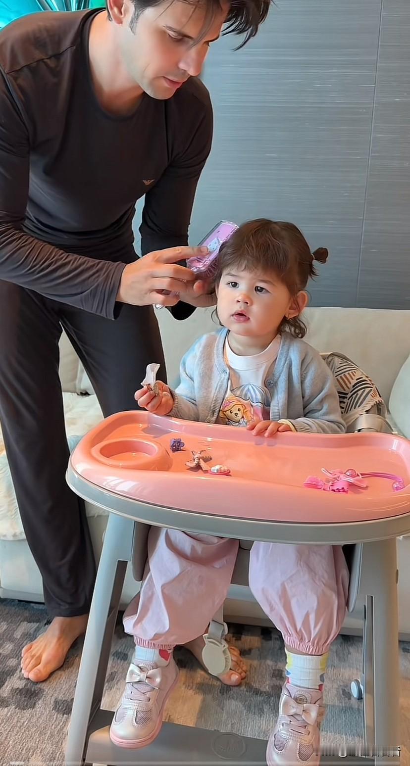 阿迪给女儿扎头发，女儿很听话，奶奶给凯莉扎头发，凯莉不让，回过头去跟奶奶摇头，谁