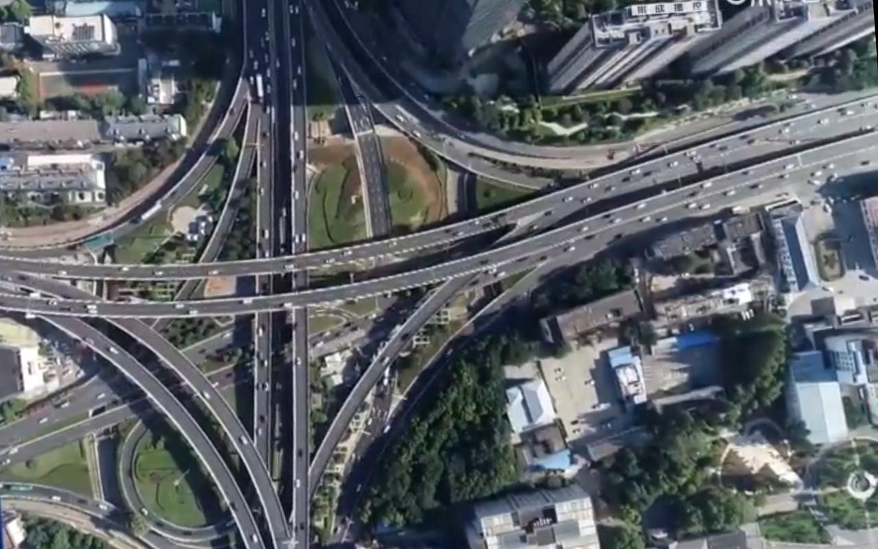 2025年我国汽车产销量再创历史新高，镜头里，纵横交错的城市交通路网、整齐排列的