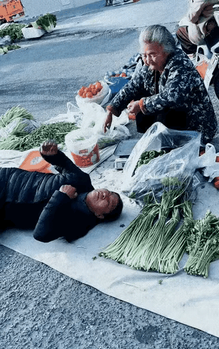 一个女的，倒在菜摊边上，身子绷得直直的，四肢一下一下地抽，嘴角都歪了。 旁边卖菜