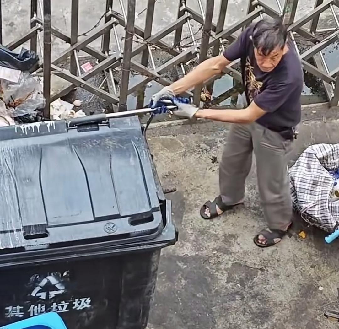 大爷趁四下无人，抽走了公共垃圾桶上的连接钢管。这钢管一抽，垃圾桶便成了无法拖运的