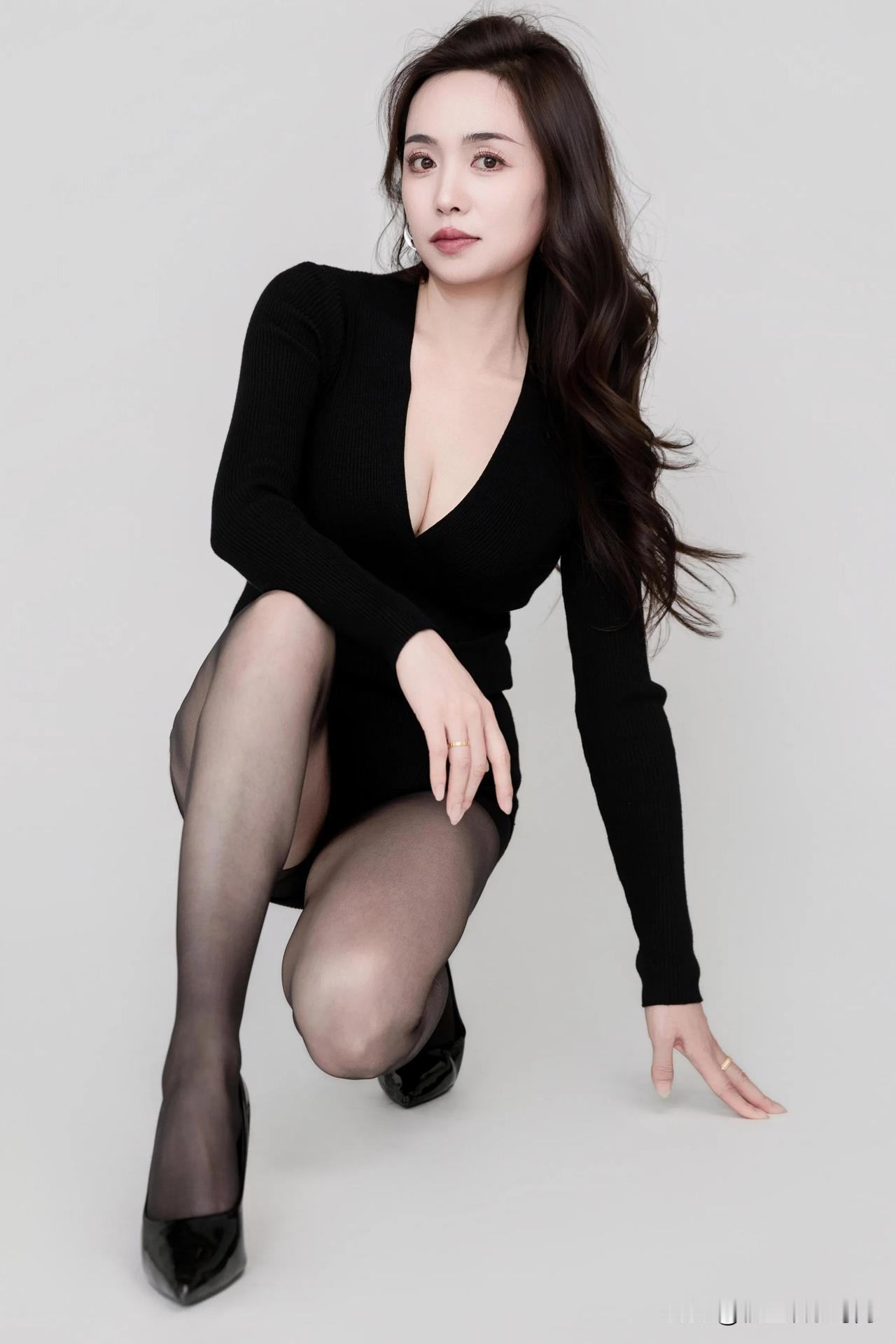 这身黑色深V长袖连衣裙贴合身形，勾勒出优雅曲线，尽显性感与干练。搭配的黑色薄款丝