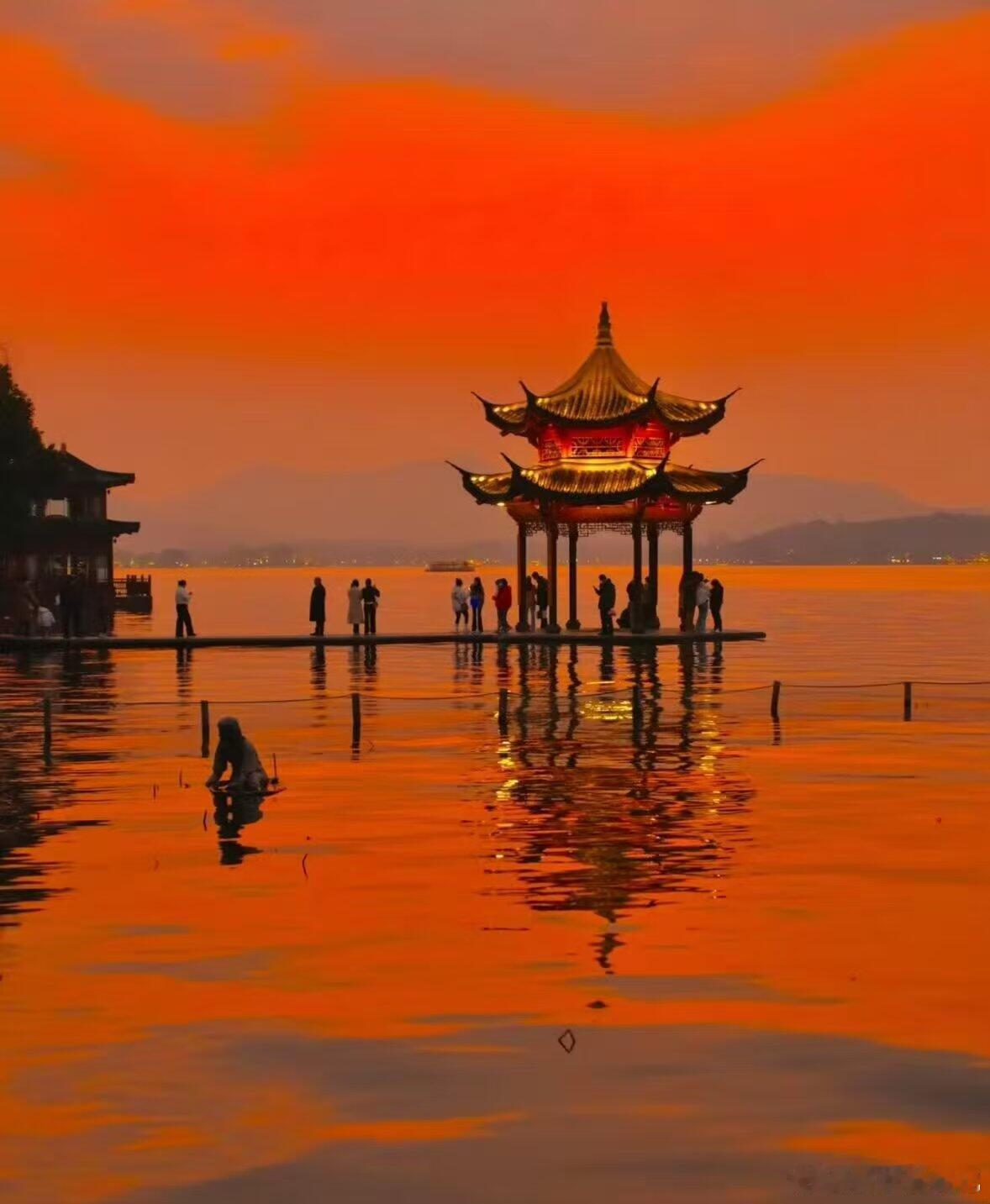 傍晚的浪漫，一半归于湖山静谧，一半藏于市井烟火。漫天橘红落日铺满湖面，古亭临水而