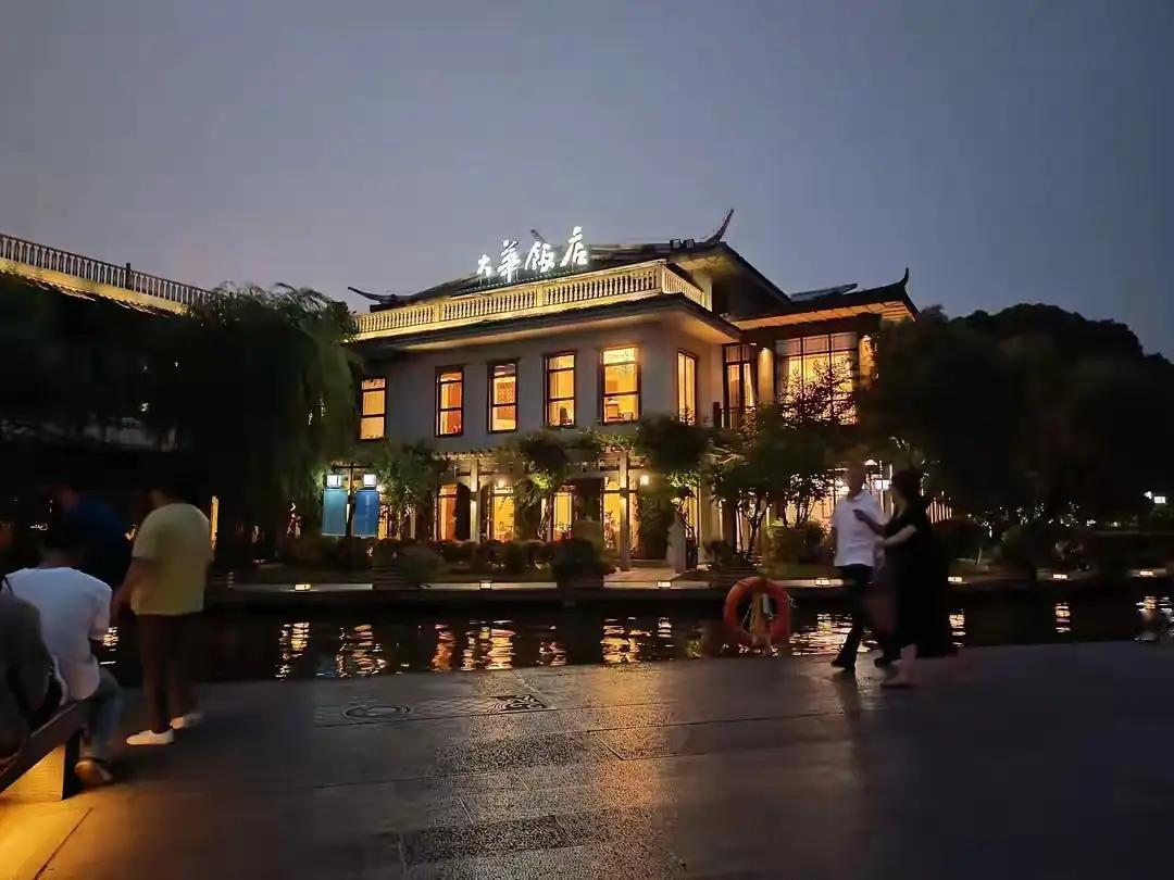 西湖夜景很美，而大华饭店对面九曲桥是观景的最佳位置。坐在石凳上抬头往远处眺望美景