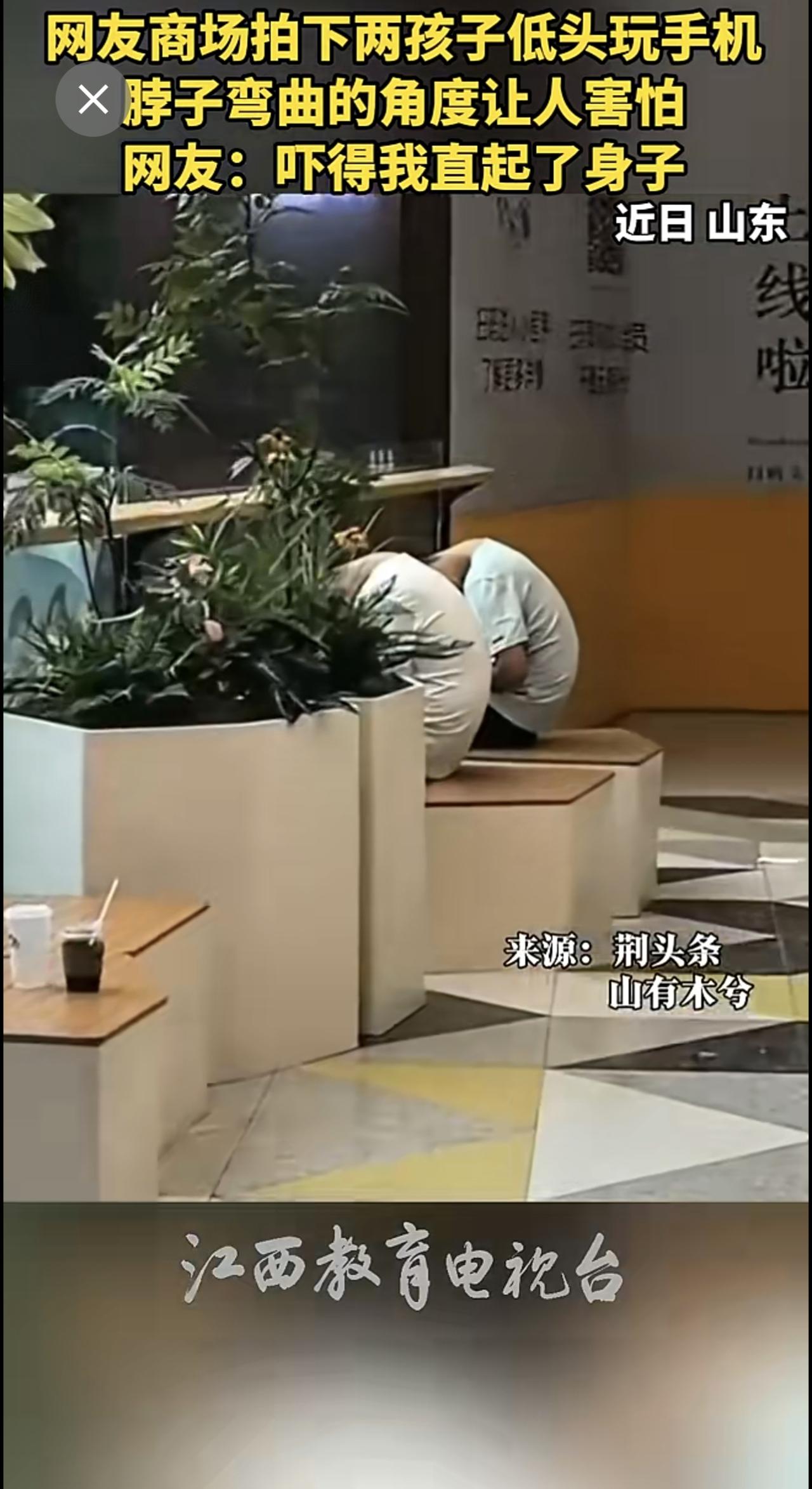 网友商场拍下两孩子低头玩手机，脖子弯曲的角度让人害怕。网友：吓得我直起了身子。（
