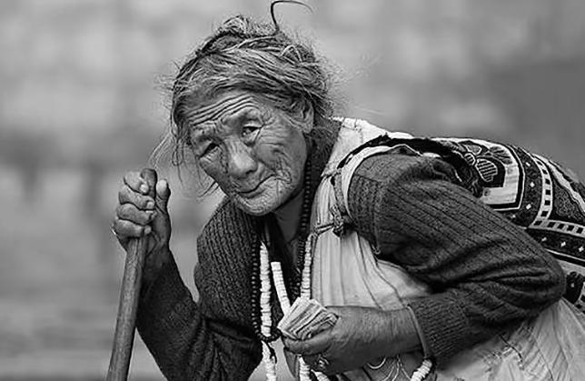 1949年，湘潭易家湾码头，一个白发苍苍、衣衫褴褛的老妇正在人群中乞讨。46军政