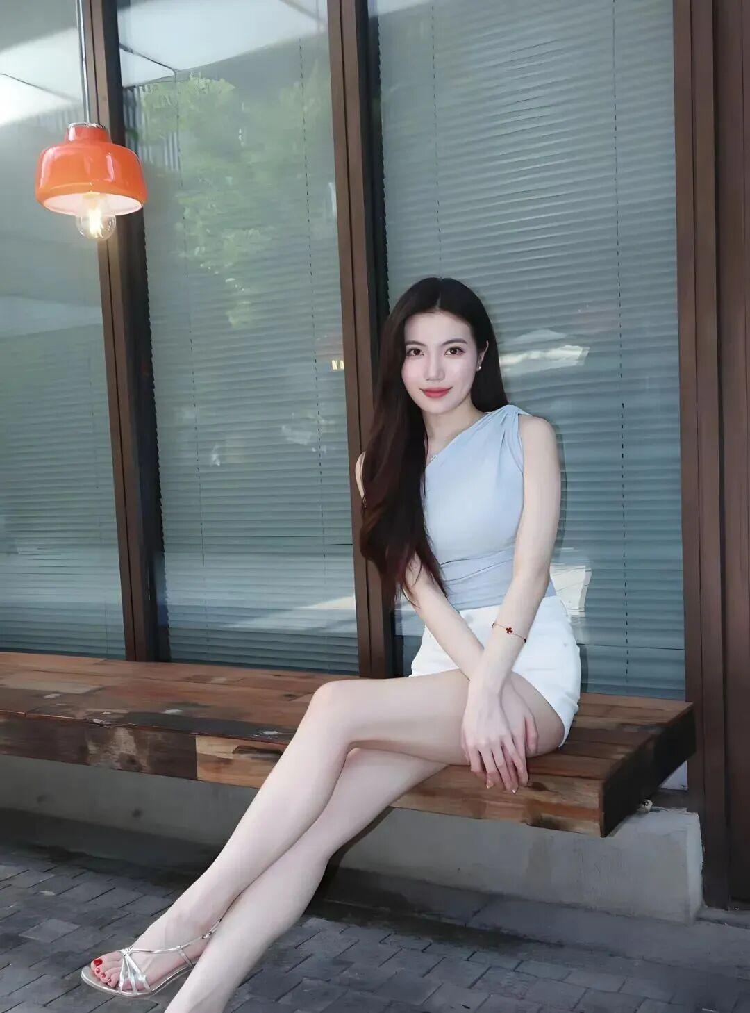 她有着一头柔顺乌黑的长卷发，眉眼精致温婉，五官清丽柔和，眼眸灵动温柔，唇色淡雅耐