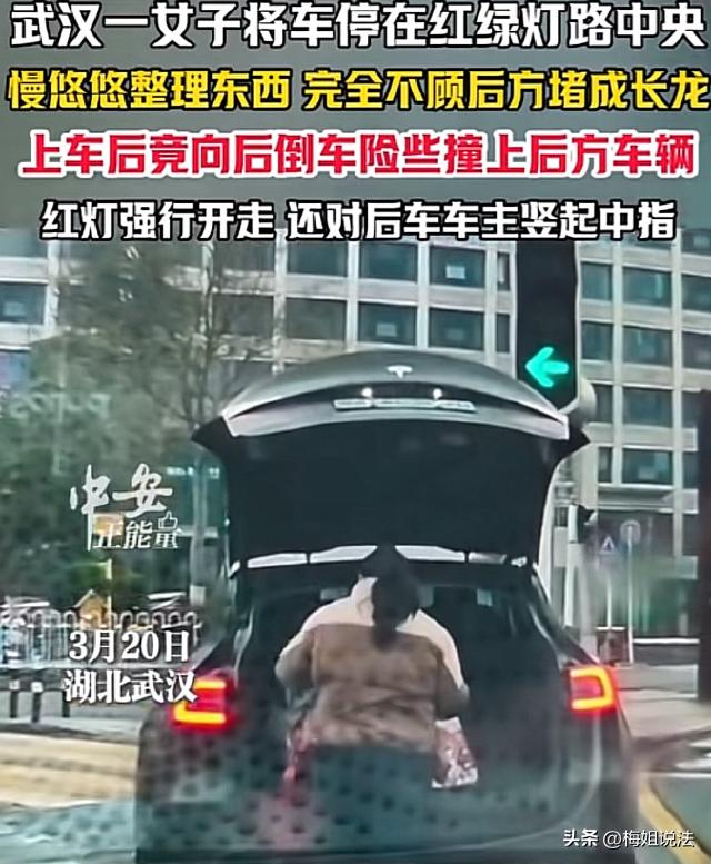 湖北武汉，一红绿灯路口，一女司机驾驶特斯拉停在路中间，不紧不慢整理后备箱，不顾后