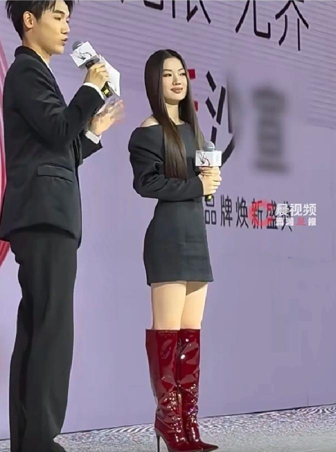 3月31日，单依纯在上海参加沙宣品牌活动，当天下着雨，她穿了黑色短裙配酒红色长靴