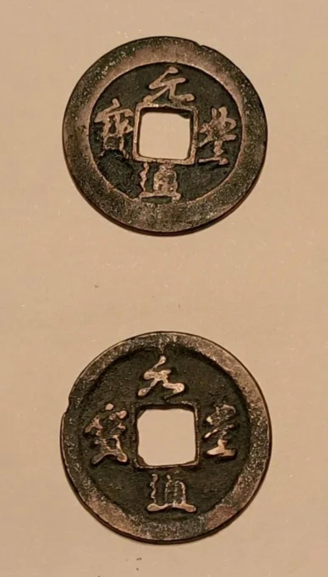 图中两枚方孔圆钱为北宋元丰通宝，铸造于宋神宗元丰年间（1078—1085年），是