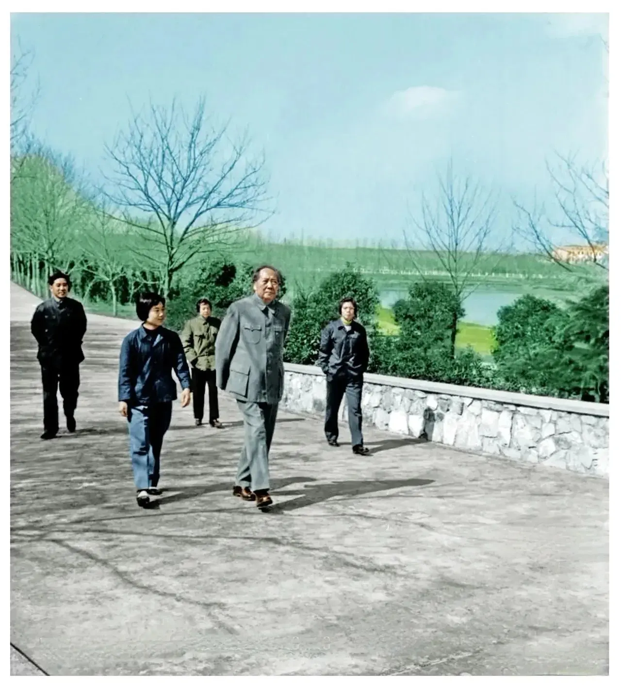 1965年毛主席和工作人员在东湖宾馆郊外散步。