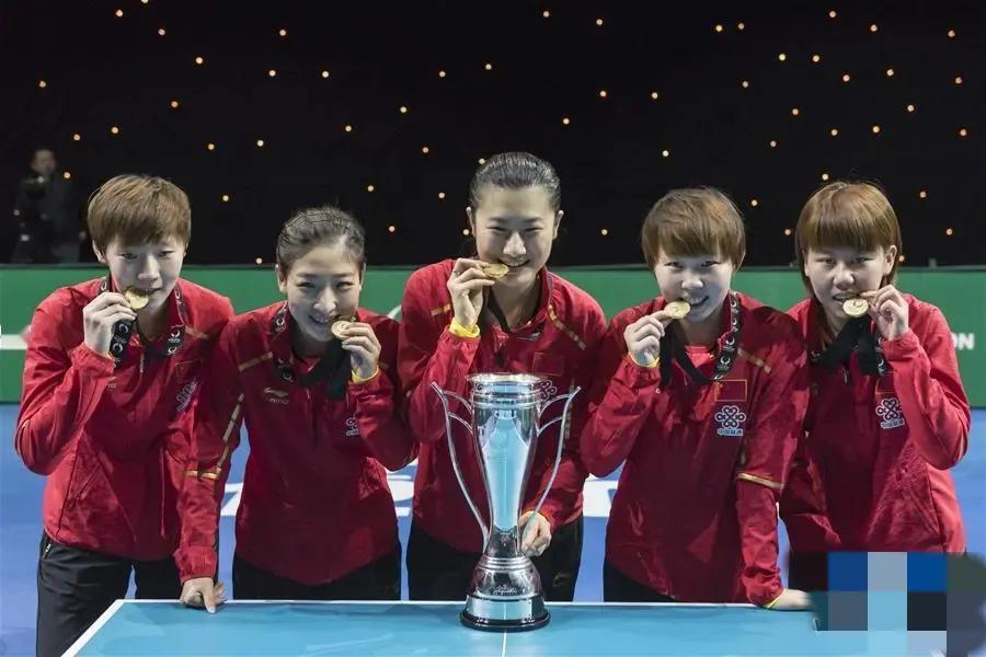 中国女乒夺冠后的合照：中间的丁宁手触奖杯笑得最为灿烂，三位短发姑娘王曼昱、朱雨玲