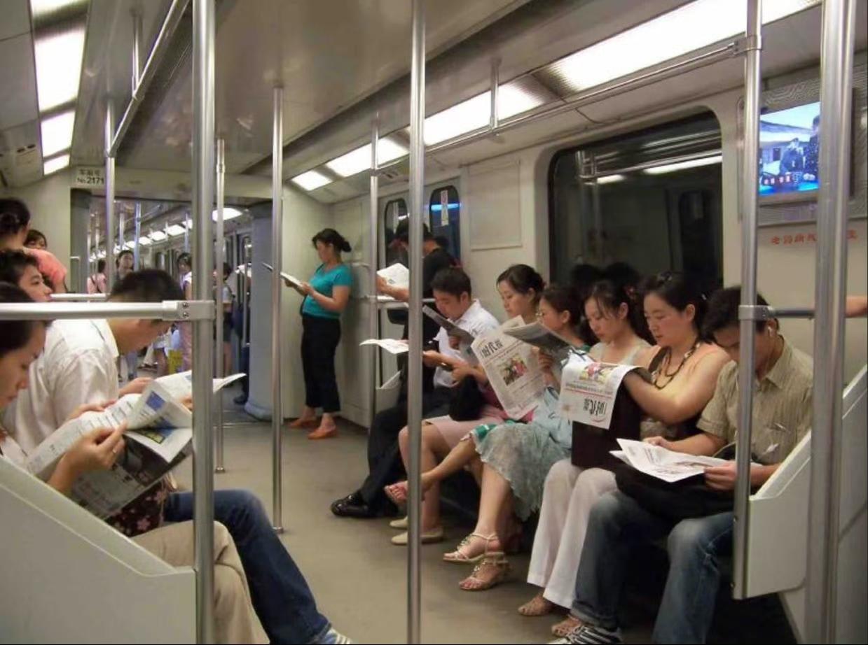 这是2006年上海地铁随拍。仔细看，那时地铁上没人看手机，都是在看报纸，那份报纸