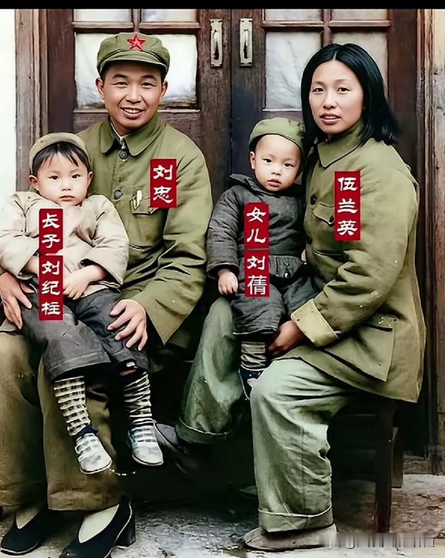 刘忠与伍兰英身着军装，
怀抱长子刘纪柱、女儿刘蒨，
一家四口笑容温暖，
定格下革