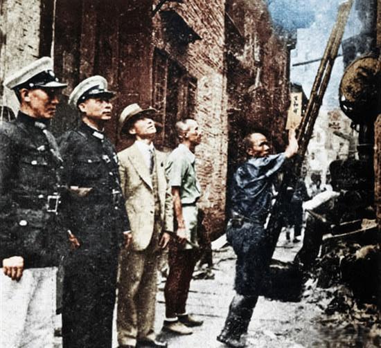 这是1936年广州老巷里的市政清洁现场，前排立着两位穿深色警式制服的公职人员，旁