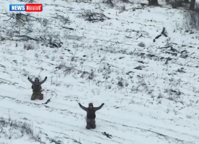 冰天雪地的荒野上，两名乌军士兵跪地举手，对着俄军无人机投降！

寒风卷着雪粒打在