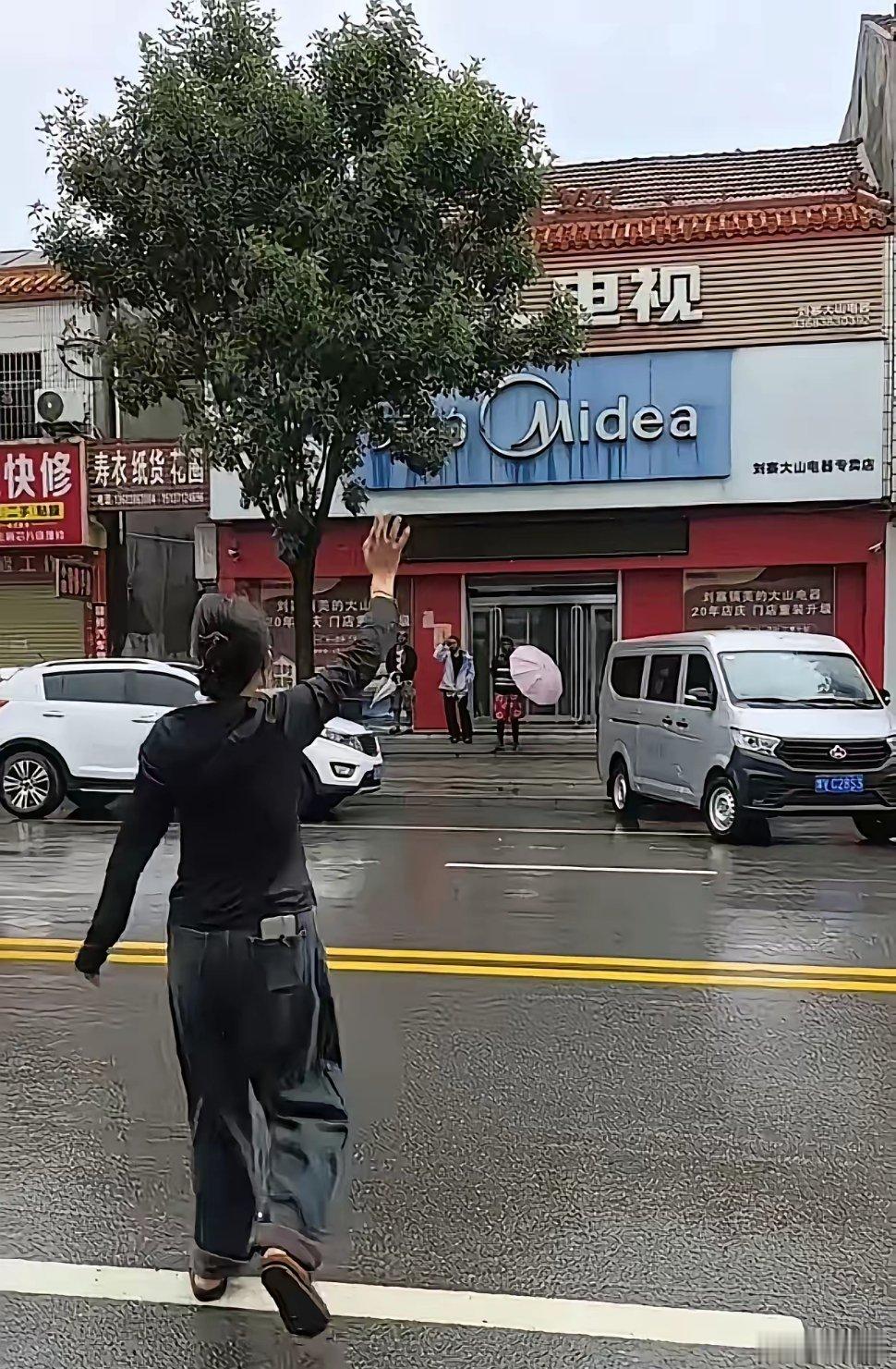近日河南，天空下着绵绵细雨，4名外国人正在避雨，这时马路对面有两名女子看到外国人