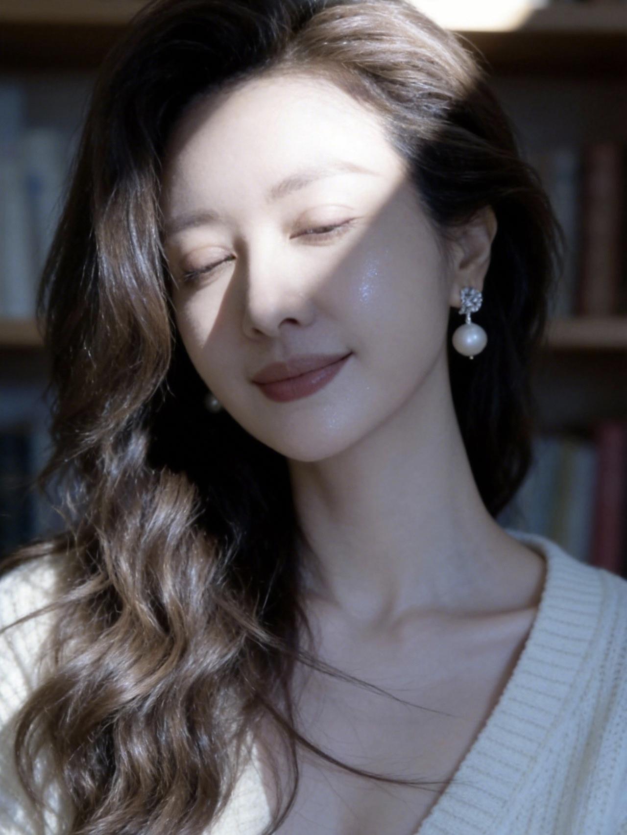 她闭着眼睛，微笑着，好温柔。