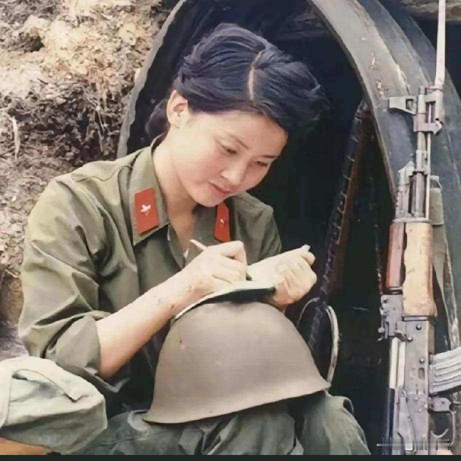 这是一名驻守在老山前线的女兵，面容清秀，举止文雅，她坐在猫耳洞前，以钢盔为桌书写
