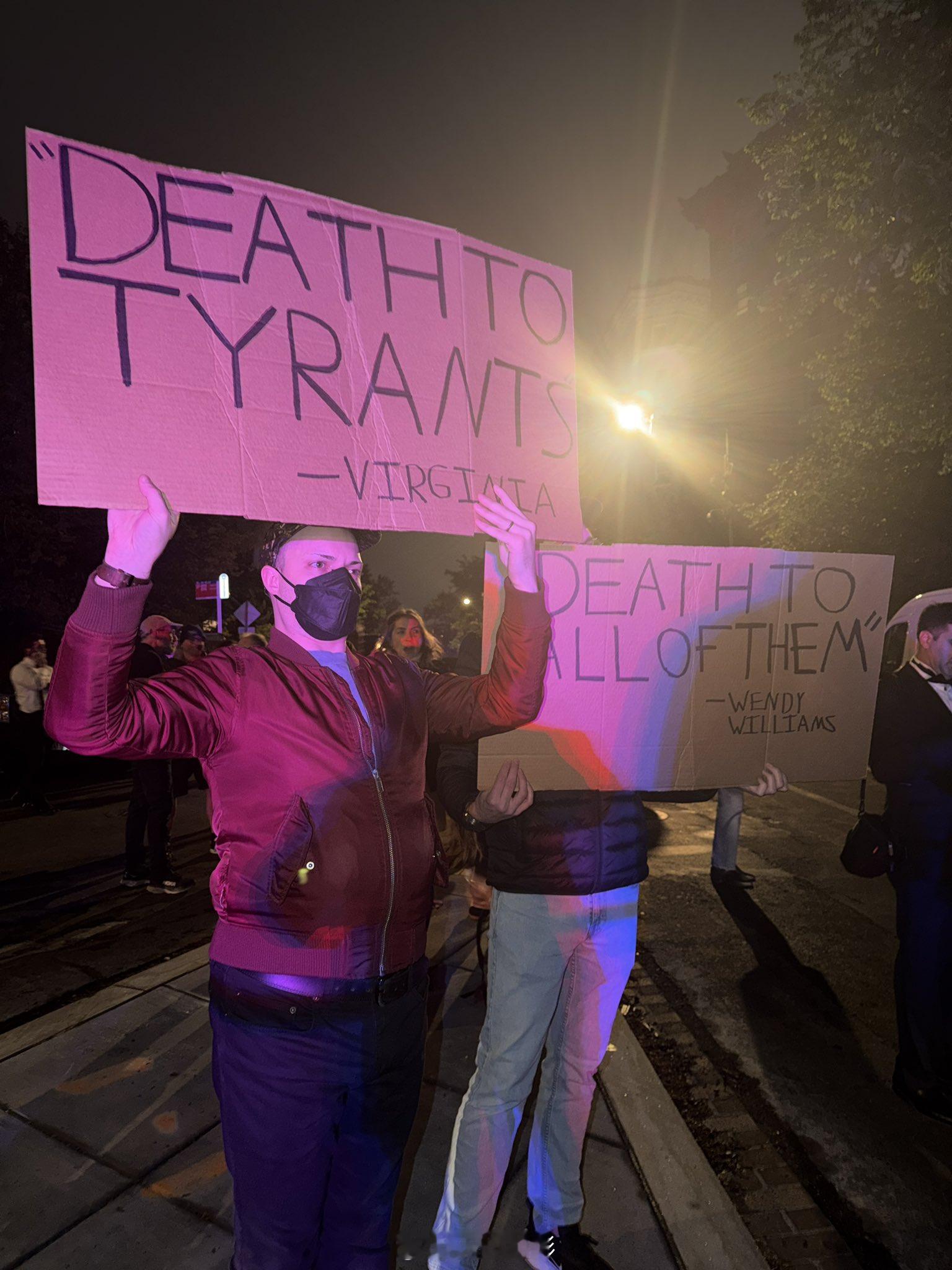 白宫记者协会晚宴发生枪击事件后，华盛顿希尔顿酒店外出现抗议者，手持标语写着“让他