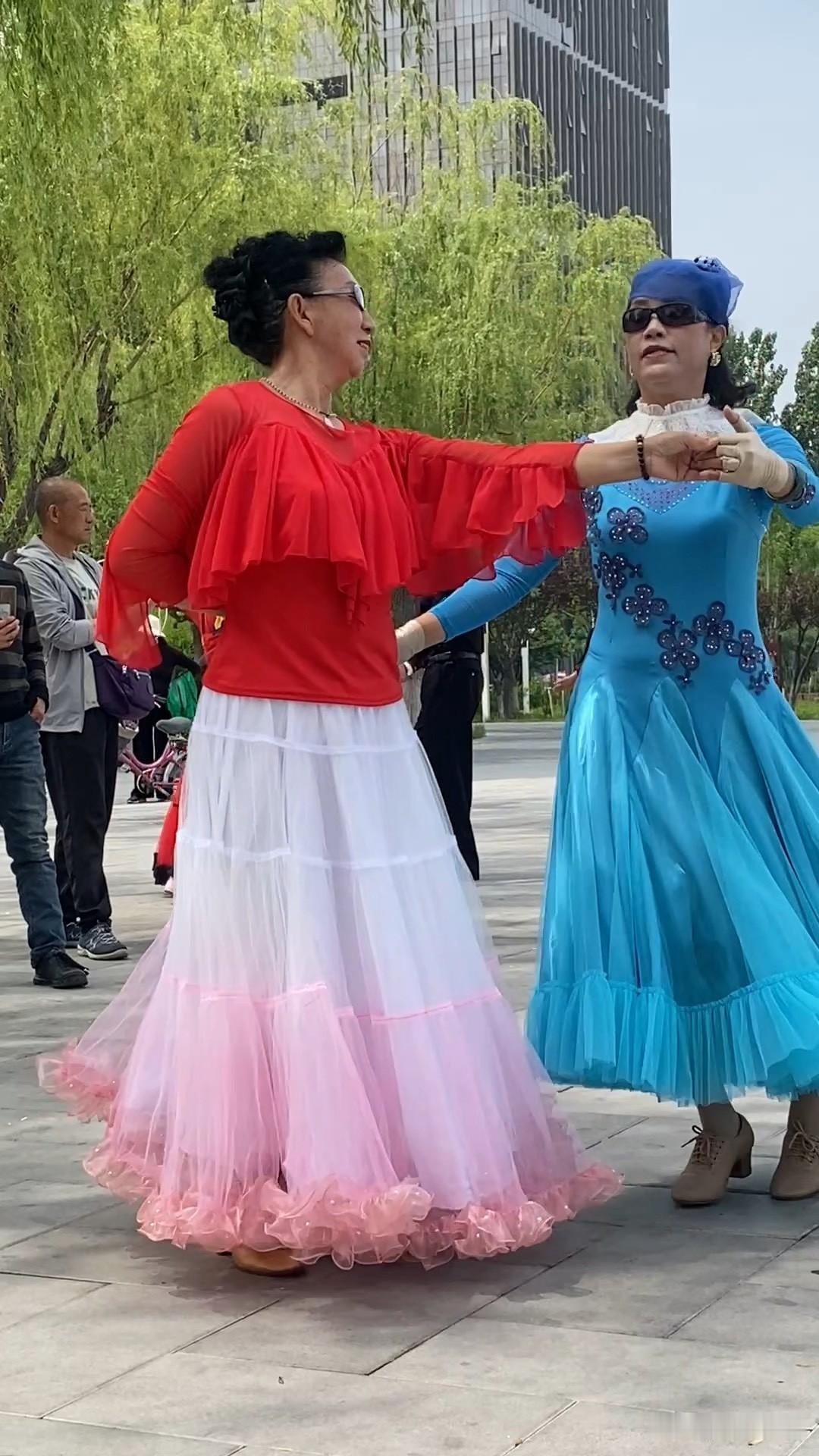 电梯口碰上孙阿姨。她穿一身大红的跳舞服，脸上汗津津的，手里还晃着把粉扇子。看见我