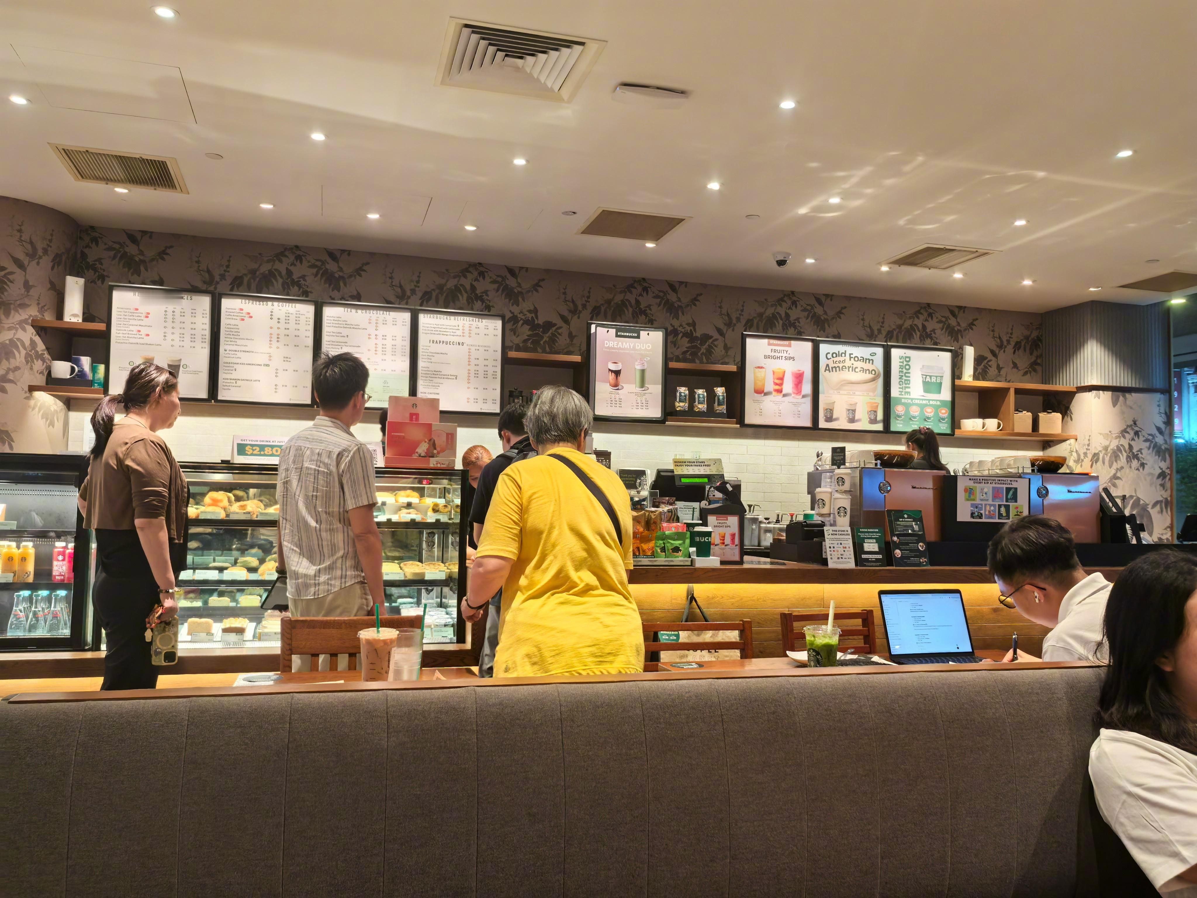刚才在新加坡的星巴克喝咖啡，没有网络下单到店喝的服务，而是排着队现场点。图中黄衣