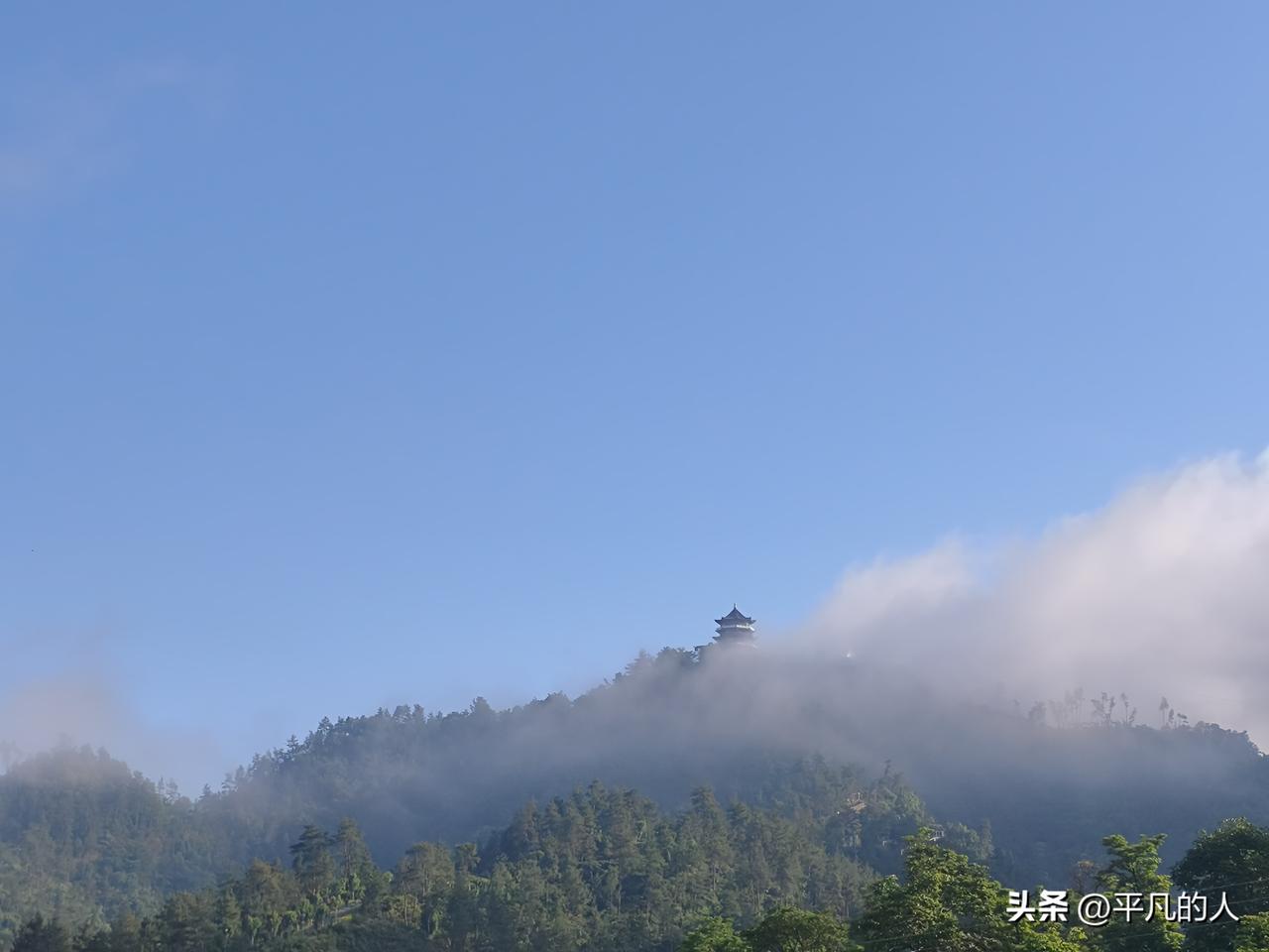 云雾漫过山腰，宝塔半隐在青山翠林之间。晴日风轻，流云作帐，山野藏着静谧悠然，抬眼