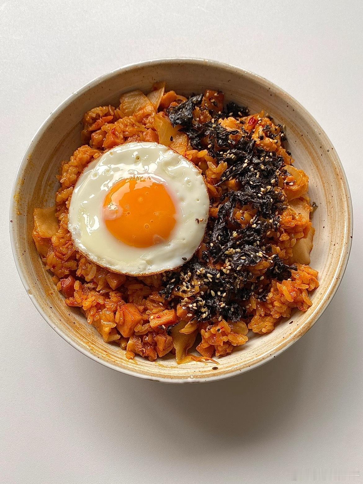 剩饭逆袭之泡菜炒饭，隔夜饭用泡菜汁抓散，加午餐肉丁大火快炒～撒海苔碎和芝麻，酸辣