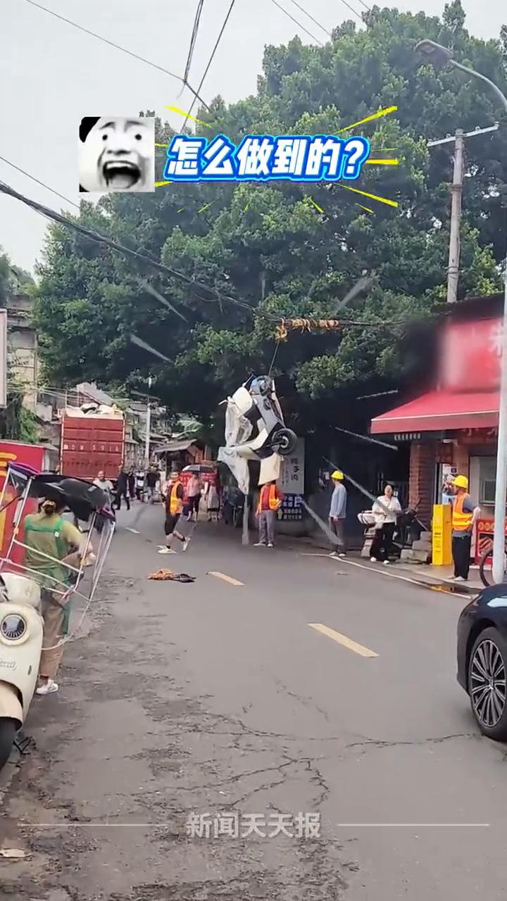 你没看错，真有电动车挂在了电线上，货物载货过高惹的祸。
新闻天天报。
怎么做到的