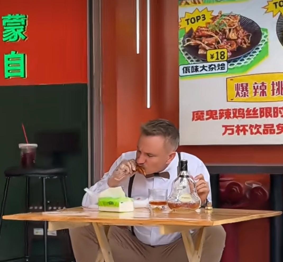 鸡爪和XO酒香气扑鼻！一位外国男子在街边地摊上喝着XO酒，啃着鸡爪，惬意非常，吃