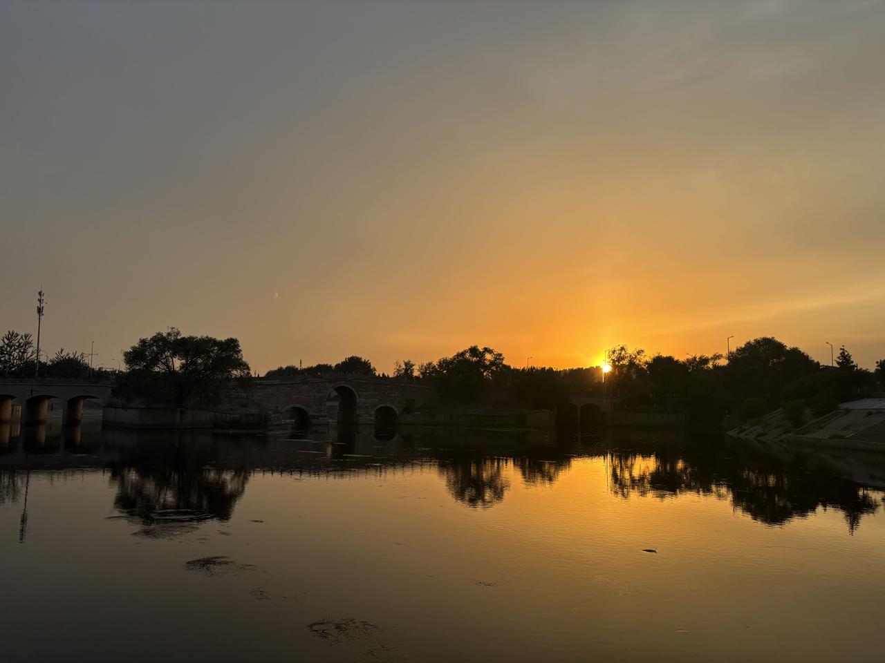 散文-夕照八里桥
 
文/青云
落日沉向天际，漫天云霞熔作满目暖金，缓缓漫过永通