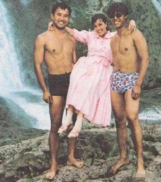 这是一张80年代的老照片。刘晓庆被两位帅哥单手抬起，笑得格外灿烂，非常开心，穿着