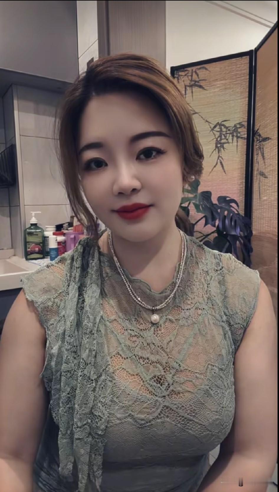 这位女士穿着蕾丝上衣，化着红唇妆。
  高清美女 养眼美照分享 高雅气质美女 美