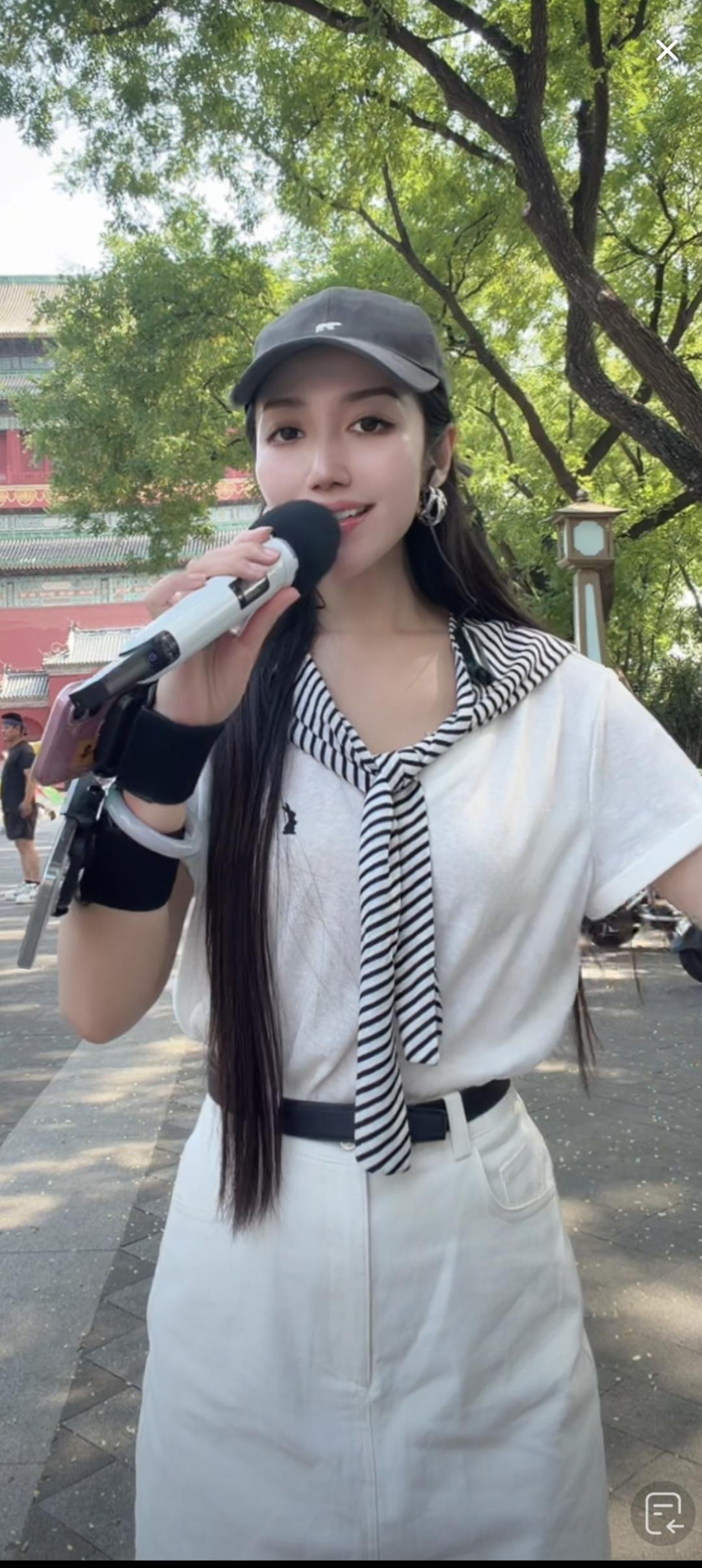 一个女孩在户外唱歌，很投入。